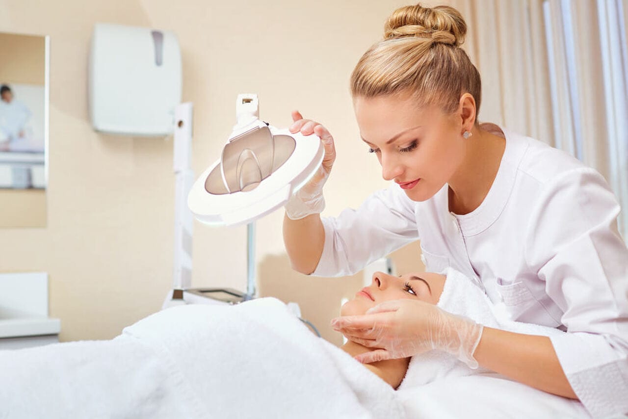 Profissional analisando flacidez em mulher deitada